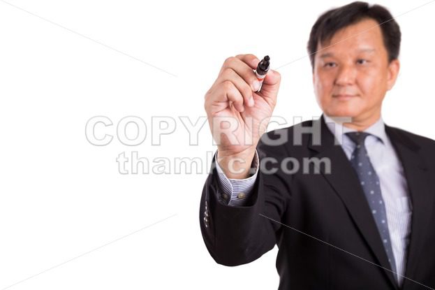 Asian business man in suit writing with marker pen - ThamKC Royalty-Free Photos