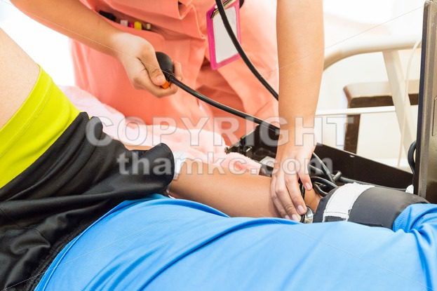 Closeup of nurse taking patient blood pressure - ThamKC Royalty-Free Photos