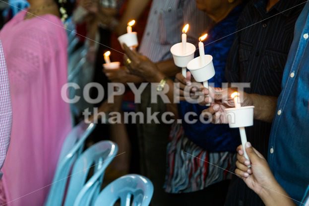 Closeup of people holding candle vigil in dark seeking hope - ThamKC Royalty-Free Photos