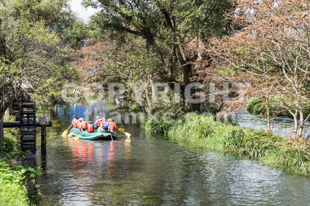 Group of people on raft peddling on serene scenic river - ThamKC Royalty-Free Photos
