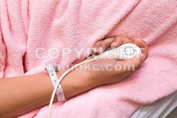 Hand holding hospital emergency nurse call button device - ThamKC Royalty-Free Photos