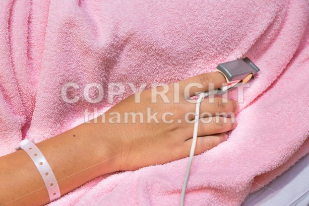 Patient finger with electronic pulse clip monitor - ThamKC Royalty-Free Photos