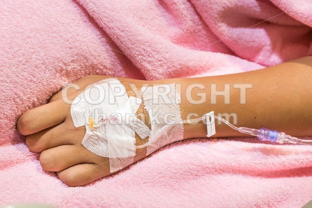 Patient hand in hospital with saline intravenous iv - ThamKC Royalty-Free Photos