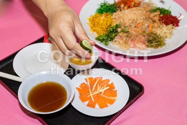 Person preparing Yee Sang or Yusheng Chinese delicacy - ThamKC Royalty-Free Photos