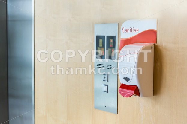 Public hand sanitizer next to elevator - ThamKC Royalty-Free Photos
