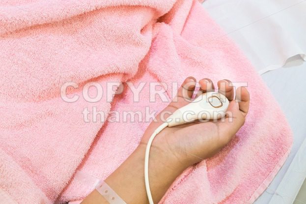 Weak hand holding hospital emergency nurse call button device - ThamKC Royalty-Free Photos