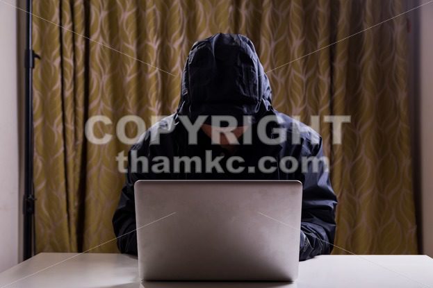 Asian hacker hacking computer network with laptop - ThamKC Royalty-Free Photos