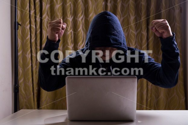 Asian hacker raise hands after successful hacked into network - ThamKC Royalty-Free Photos