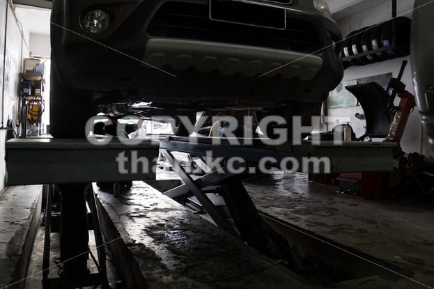 Silhouette of mechanics repairing car at small workshop garage - ThamKC Royalty-Free Photos