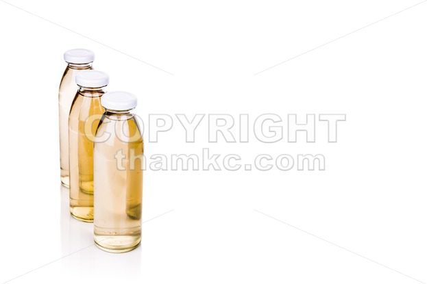 Three translucent liquid in glass bottle on white background - ThamKC Royalty-Free Photos