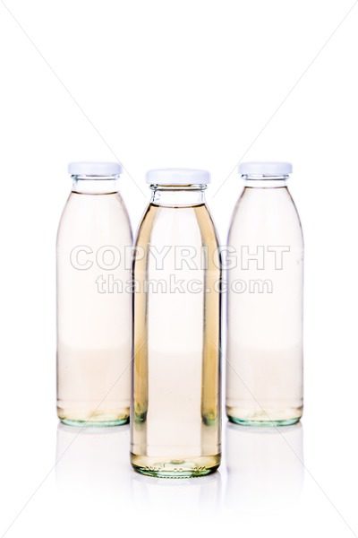 Translucent liquid in glass bottle on white background - ThamKC Royalty-Free Photos