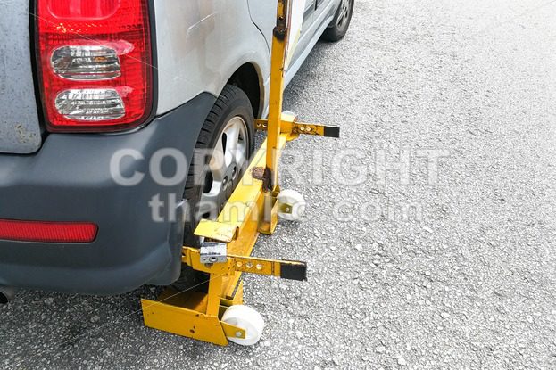 Car wheel clamp on street for illegal parking - ThamKC Royalty-Free Photos
