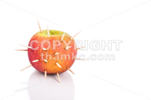 Conceptual of apple with thorns denote sharp pain when bite - ThamKC Royalty-Free Photos