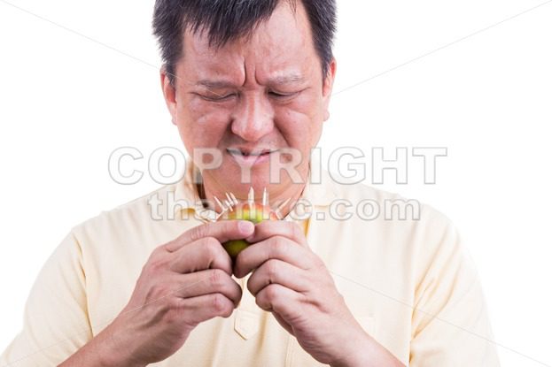 Conceptual of man hesitate to bite apple with thorns - ThamKC Royalty-Free Photos