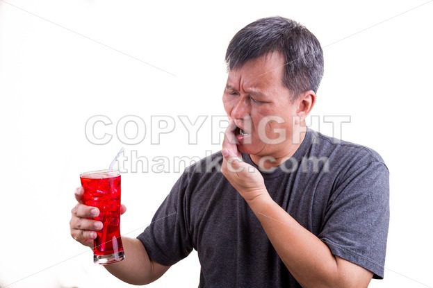 Focus on ice cold drink with man with toothache background - ThamKC Royalty-Free Photos