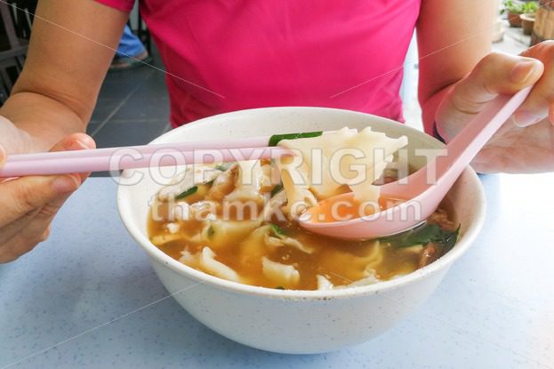 Person eating flat flour noodle soup or Pan Mee cuisine - ThamKC Royalty-Free Photos
