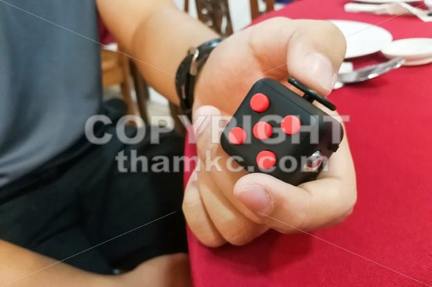 Person hand enjoy, play, relieve with the fidget cube - ThamKC Royalty-Free Photos