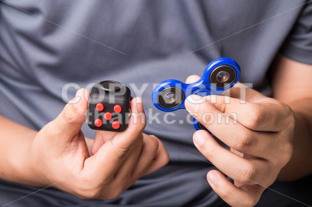 Person hand holding the fidget spinner and fidget cube - ThamKC Royalty-Free Photos