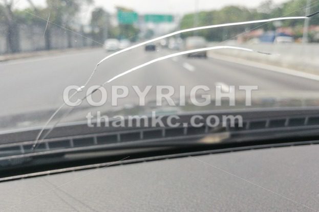 Perspective view of cracked car windscreen or windshield while driving - ThamKC Royalty-Free Photos
