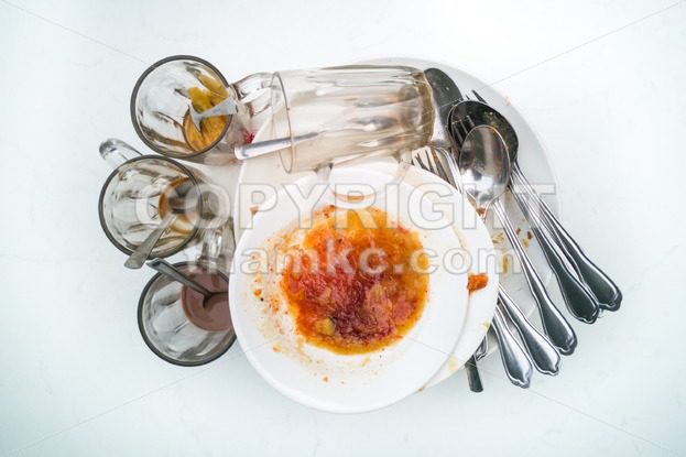 Pile of dirty oily plates, glass, fork spoons after meal - ThamKC Royalty-Free Photos