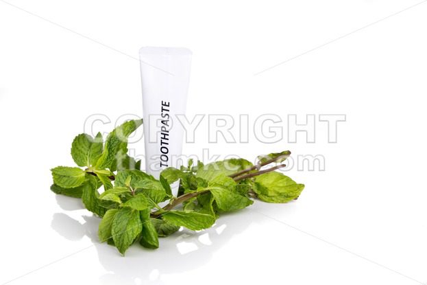 Soft tapered bristle toothbrush with toothpaste and mint leafs - ThamKC Royalty-Free Photos