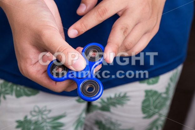 Teenager attempt to spin the fidget spinner - ThamKC Royalty-Free Photos