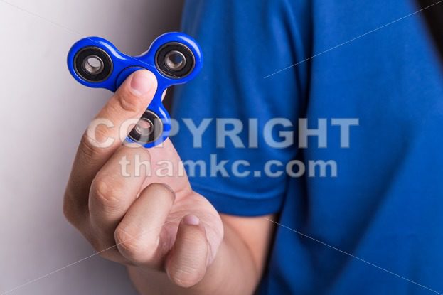 Teenager holding the fidget spinner - ThamKC Royalty-Free Photos