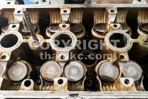 Worn uto car engine valves being serviced at garage - ThamKC Royalty-Free Photos