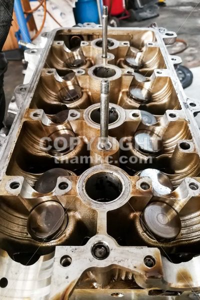 Worn uto car engine valves being serviced at garage - ThamKC Royalty-Free Photos