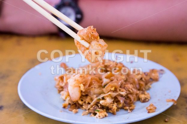 Chopstick holding big prawn from Penang Char Kuey Teow - ThamKC Royalty-Free Photos