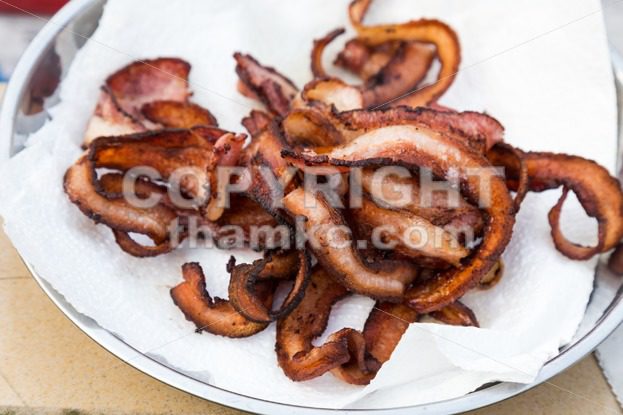 Crispy delicious fried bacon strips but unhealthy with burnt carbon - ThamKC Royalty-Free Photos