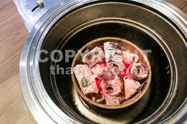 Korean restaurant barbecue pit with hot red charcoal - ThamKC Royalty-Free Photos