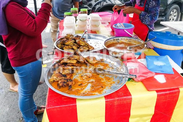 Muslim shoppers buying food from street vendor for breaking fast or iftar - ThamKC Royalty-Free Photos