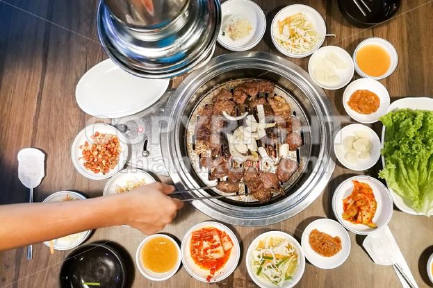 Person barbecue beef on bbq pit during korean meal set - ThamKC Royalty-Free Photos