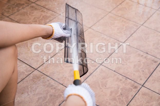 Person spraying water onto air conditioner filter to clean dust - ThamKC Royalty-Free Photos