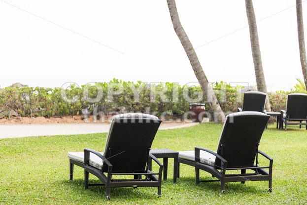 Relaxing deck chairs at tropical resort with nobody - ThamKC Royalty-Free Photos