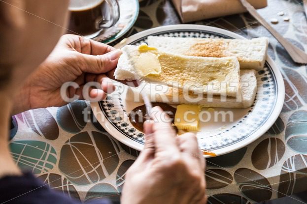 Series of person applying butter and kaya to steamed bread - ThamKC Royalty-Free Photos