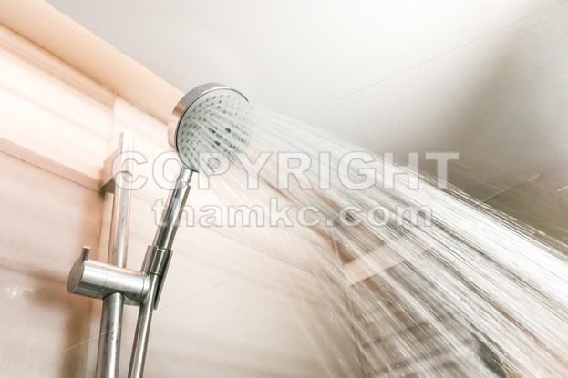 Shower head with refreshing water droplets spray in bathroom - ThamKC Royalty-Free Photos