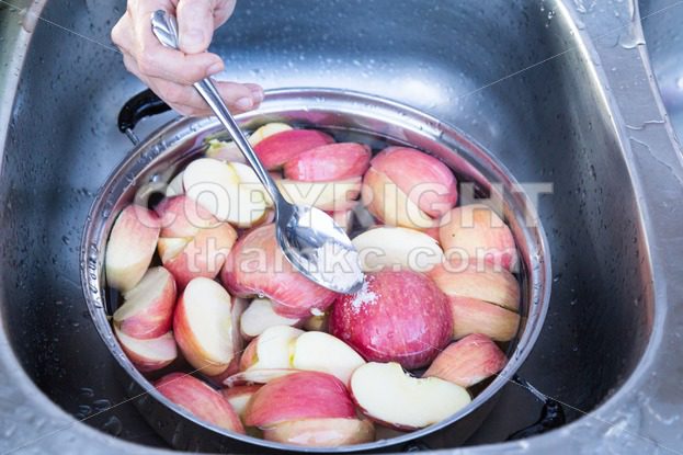 Soak apple in water with salt to prevent oxidation - ThamKC Royalty-Free Photos