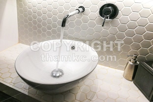 Modern wash basin with running water from tap faucet - ThamKC Royalty-Free Photos