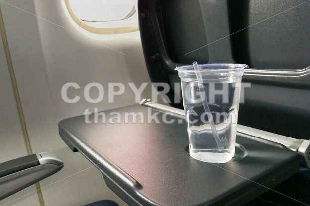 Disposable refreshing mineral water on table in air plane cabin - ThamKC Royalty-Free Photos