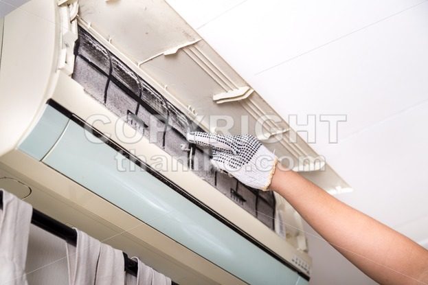 Technician pointing to air conditioner filter full of trapped dust - ThamKC Royalty-Free Photos